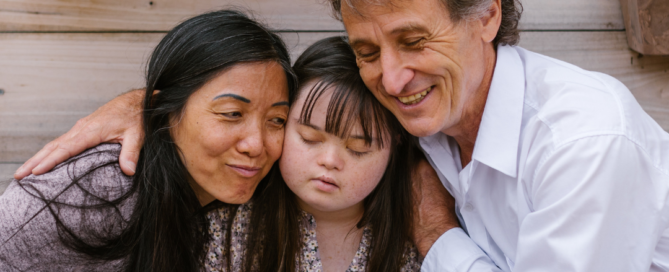 A mixed-ethnicity family hugging to show how counselling can help family issues.